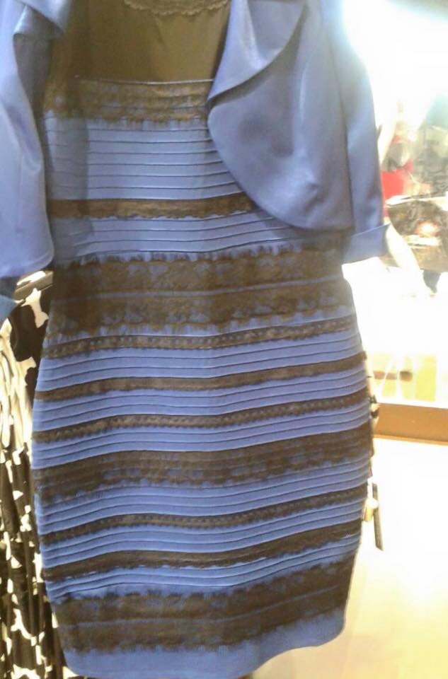 The original 2015 photo of the dress: a striped lace bodycon dress on a shop hanger, under bright, washed-out light. Some people see it as blue and black, others as white and gold.